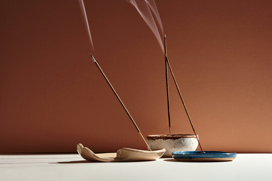 A set of burning incense for yoga or meditation. Minimalistic concept with warm colors