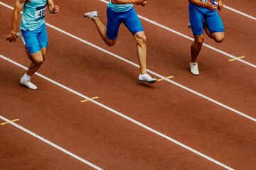 group male runners run on track stadium in track and field competition