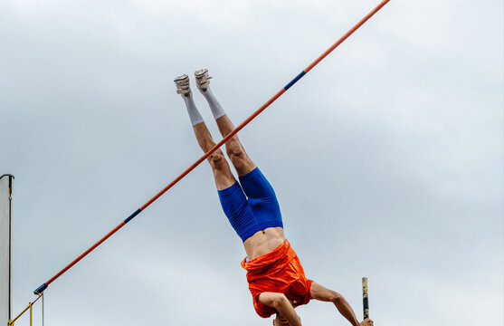 pole vault male athlete on blue sky background