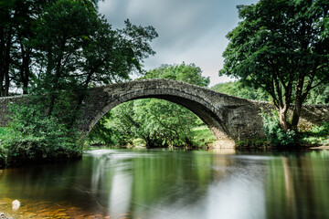 Fototapeta na wymiar Bridge in the Yorkshire Dales with long exposure to produce out of focus blurred water