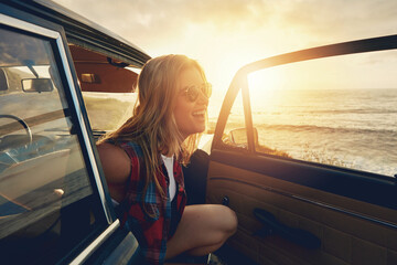 Fototapeta premium Woman, sunset and beach road trip by car door with smile, freedom and happiness for summer vacation. Happy gen z girl, suv and sunglasses for sunshine, outdoor adventure or holiday by waves on travel