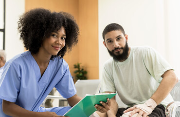 Obraz premium African American woman doctor in uniform with beard man patient in hospital, Hospital Concept