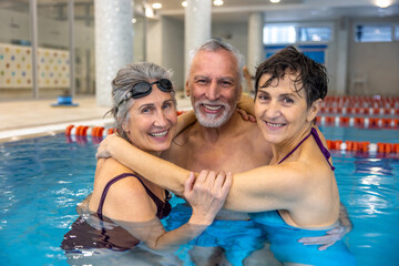 Fototapeta na wymiar Group of seniors at the swimming pool looking happy and enjoyed