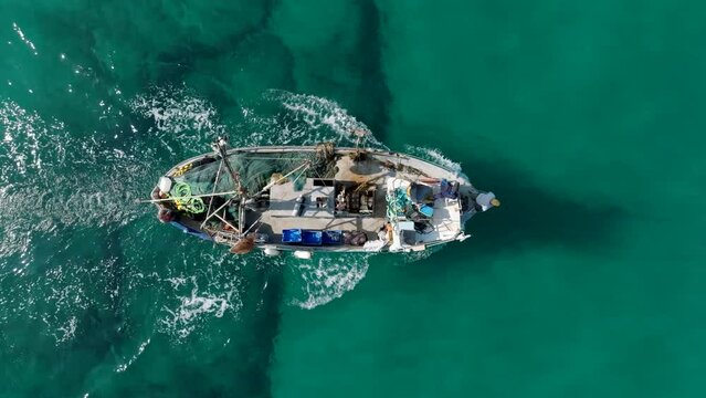 Aerial Footage of a fishing boat sailing towards the port of the beautiful old city of Jaffa, Tel Aviv.