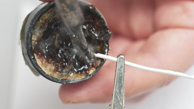 men's hands soldering iron and rosin make tinning wire for soldering. 