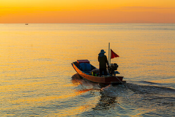 fisherman,A silhouette of a fisherman with a yellow and orange sun in the background.