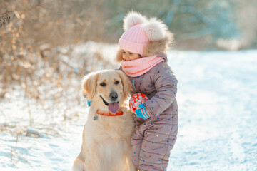 Young girl portrait playing active game with her dog golden retriever