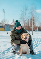 Man embrace with a dog golden retriever outdoors