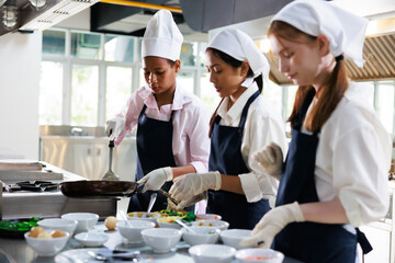 Group of student girl learning. Cooking class. culinary classroom. group of happy young woman multi - ethnic students are focusing on cooking lessons in a cooking school.