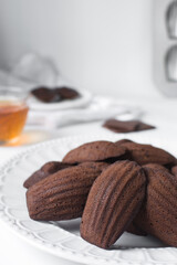 Chocolate madeleines on a ceramic plate, plain chocolate madeleine cake or cookies