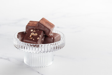 Chocolate bonbons with praline on white marble background