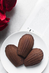 Top view of Chocolate madeleines on a marble tray, plain chocolate madeleine cake or cookies