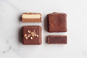 Chocolate bonbons with praline on white marble background