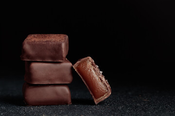 Chocolate bonbons with caramel on black background