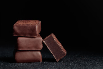 Chocolate bonbons with truffle on black background