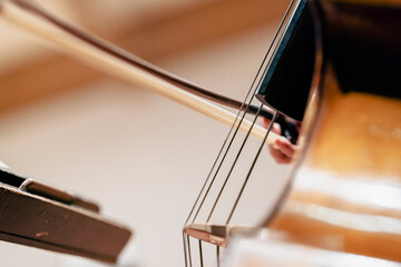 A double bass bow going across strings