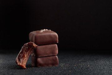 Chocolate bonbons with caramel on black background