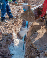 Excavator electrical conduits covered with sand