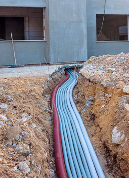 Excavation pit, electrical cables and optical fibres in the digging on a construction site