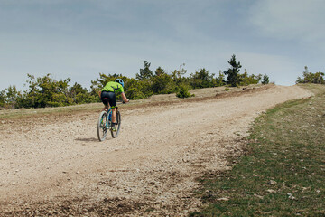 Obraz premium male athlete on mountain bike riding uphill on trail
