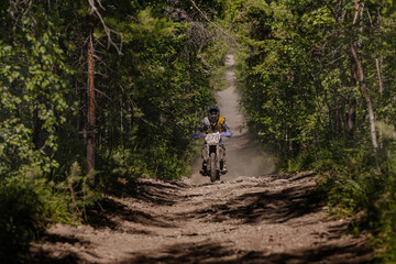 male enduro motorcycle racer riding on forest