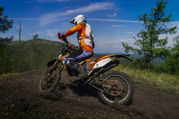 Fototapeta na wymiar enduro motorcycle racer riding dusty trail