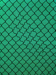 Chain-link fencing with the diamond pattern and green fiber screening as background