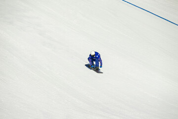 athlete snowboarder downhill. background of white snow