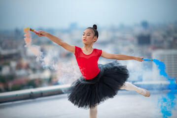 Cute little ballet dancer performing handstand posture while practicing dance form on terrace wearing ballerina costume