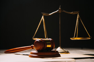 Justice and law concept.Male judge in a courtroom with the gavel, working with, computer and docking keyboard, eyeglasses, on table in morning light