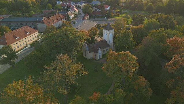 german village with church in park at sunset. Stunning aerial view flight drone