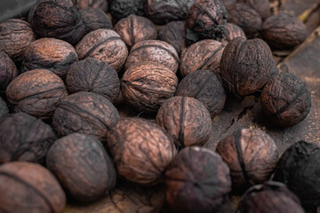 Walnuts in shell. Lots of nuts. A dirty nut shell. Benefits of walnut. Energy snack. Natural products. Gifts of nature. Autumn harvest. Vitamins in nuts.