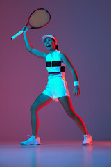 Portrait of young professional female tennis player in sports uniform in motion, action over gradient pink-purple background in neon light. Sport, fashion, energy, motivation concept