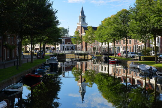 The historic city center of Weesp, a small town located in the East of Amsterdam, North Holland, Netherlands, with reflections of historic houses and boats on the Oudegracht canal 