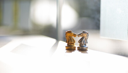 The chess knights face each other. Chess board game concept of business ideas and competition and strategy ideas concep. Chess figures on a dark background with smoke and fog.