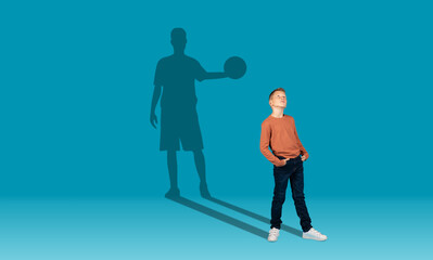 Boy and shadow of sportive male basketball player on wall