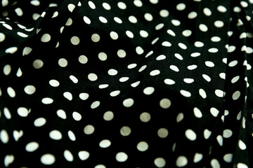 Polka dot patterned black and white fabric textile folded cloths as background