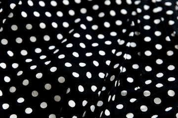 Polka dot patterned black and white fabric textile folded cloths as background