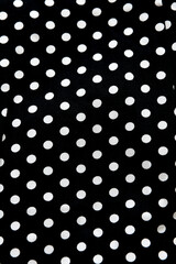 Polka dot patterned black and white fabric textile folded cloths as background