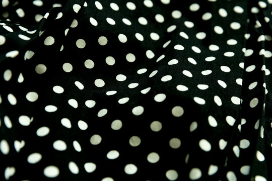Polka dot patterned black and white fabric textile folded cloths as background