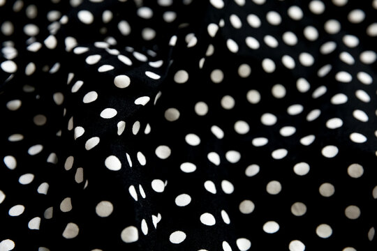 Polka dot patterned black and white fabric textile folded cloths as background