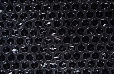 Plastic packaging material with air bubbles on black background