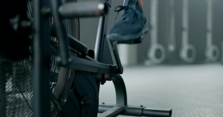 Fitness, legs and feet in cycling at gym on stationary bike for healthy cardio workout, exercise or training. Leg and foot of sporty athlete riding or exercising on bicycle equipment at the gymnasium