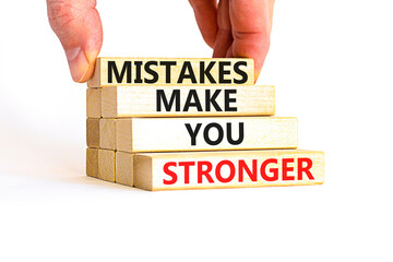 Mistake make stronger symbol. Concept words Mistakes make you stronger on wooden blocks. Beautiful white background. Businessman hand. Business mistake make stronger concept. Copy space.