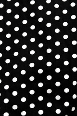 Polka dot patterned black and white fabric textile folded cloths as background