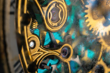 The view is close. Mechanism of a wristwatch. Gears, levers, springs and gems. Engraving and gold. old scratched glass. Concept of repair and service. Selective focus.