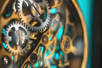 The view is close. Mechanism of a wristwatch. Gears, levers, springs and gems. Engraving and gold. old scratched glass. Concept of repair and service. Selective focus.