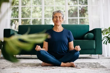 Schilderijen op glas Relaxing the mind and finding inner peace with yoga: Senior woman meditating at home © (JLco) Julia Amaral