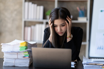 Asian businesswoman are stressed while working on laptop, Tired asian businesswoman with headache at office, feeling sick at work.