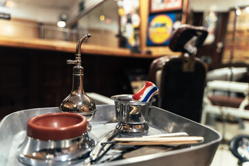 Obraz premium Close up view of a silver plate with barber tools